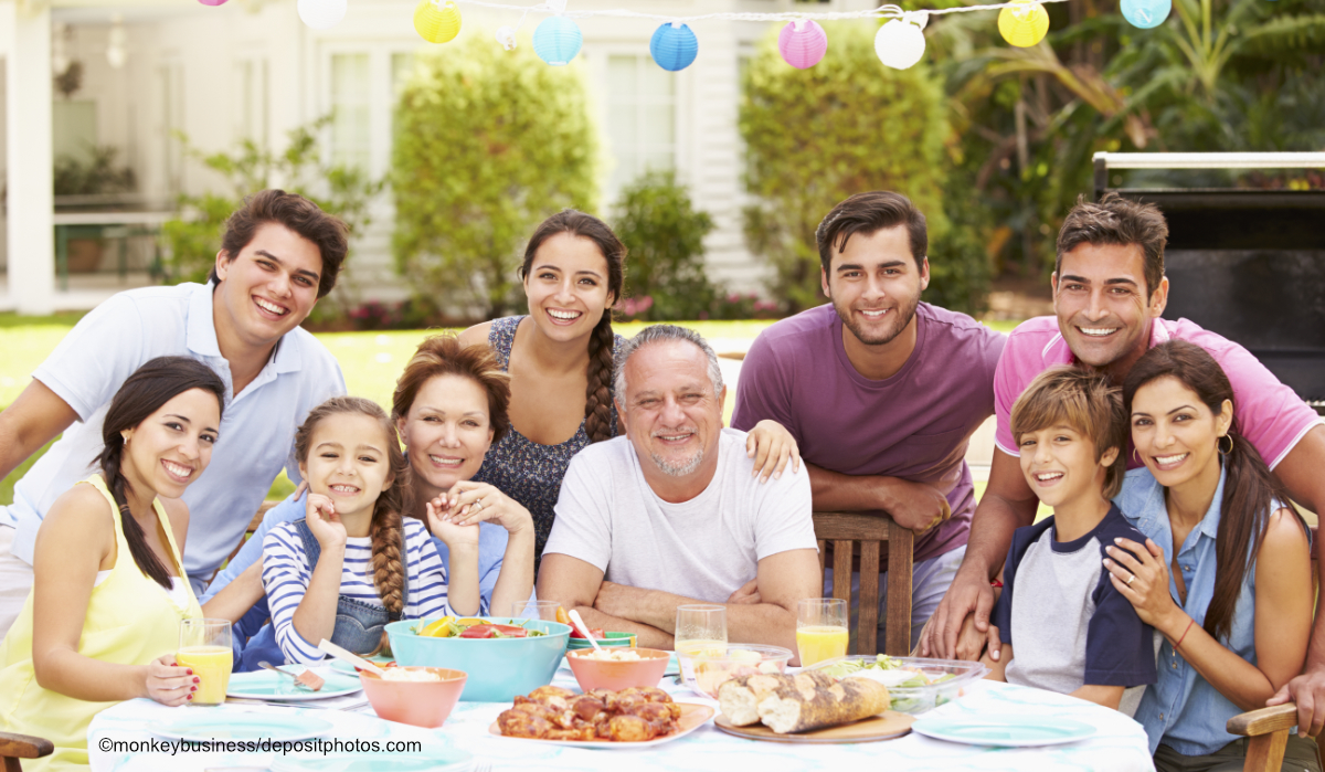 Großfamilie beim Essen an einer festlichen Tafel im Garten